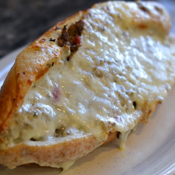 A close-up of a cheesy sausage and pepper hero sandwich from Ray's Pizza.